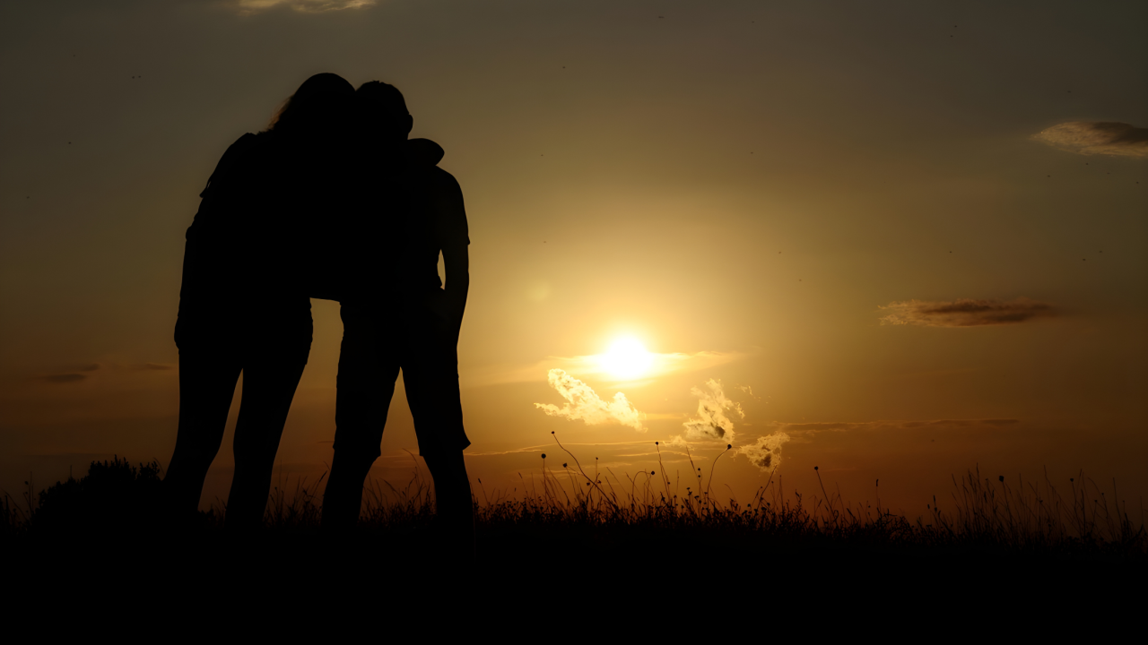 Parent and child embracing in front of a sunset